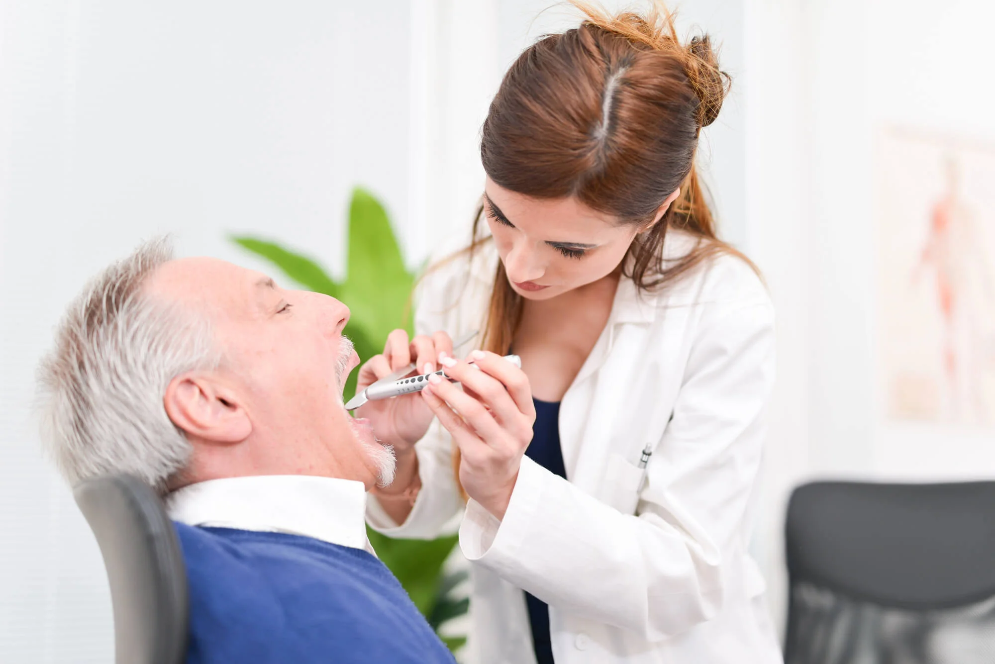 Dentist checking a patient’s mouth, Oral Cancer Screenings in Seneca